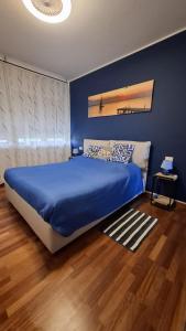 a bedroom with a bed with a blue wall at Seaview Beach Front Grado Pineta Andromeda in Grado-Pineta +29 photos