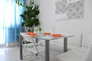 a dining room with a glass table and white chairs at Alex Botique in Varna City