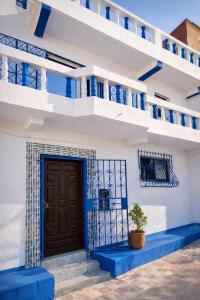 a blue and white building with a door and a potted plant at Blue Tizirin House in Tamraght Ouzdar