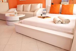 two white beds in a room with a couch at Alex Botique in Varna City
