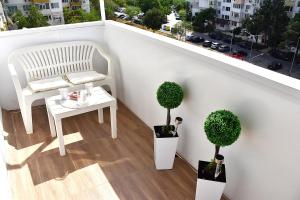 a balcony with a white chair and two potted plants at Alex Botique in Varna City