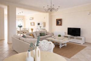 a living room with a couch and a table at Melitta Villa in Ágios Ioánnis
