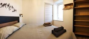 a bedroom with a bed with two chairs and a window at Casa Nonna Giovanna in Tesero +29 photos