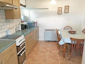 a kitchen with a table and a table and chairs at The Cottage in Gosforth