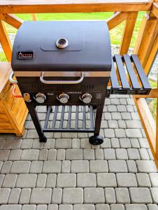 a grill sitting on a table on a patio at Domki Oaza Ciszy in Polańczyk +3 photos