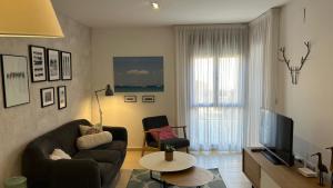 a living room with a couch and a television at Apartamento La Calma in Lliber
