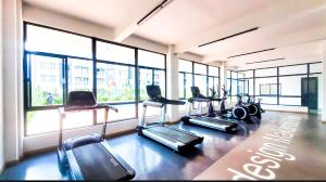 a gym with several treadmills in a room with windows at Urban Homes-Two Bedroom Near JKIA Airport in Nairobi