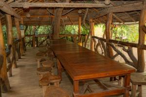 a long wooden table in a pavilion with stools at Sayon River Cottage in Wellawaya