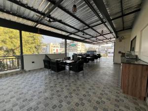 a dining room with tables and chairs and large windows at Hotel Central Park Inn, in Dehradun