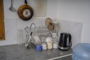 a kitchen counter with dishes and a mirror on the wall at Melaka Hill in Culik