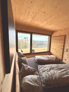 two beds in a room with a large window at Wohnen am Südhang in Amberg