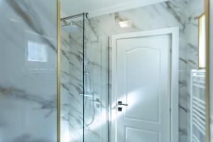 a shower with a glass door in a bathroom at Jolie Boutique Hotel in Craiova +209 photos