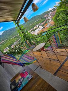 two chairs and a table on a balcony with a view at Urban Hostel Pool & Garden in San Gil