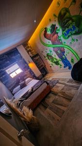 a bedroom with a dinosaur mural on the wall at Urban Hostel Pool & Garden in San Gil