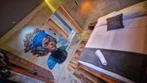 a bedroom with a painting of a woman on the wall at Urban Hostel Pool & Garden in San Gil