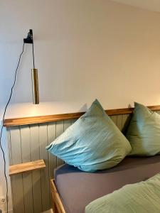 a bed with two pillows on it with a lamp at Stadtwohnung Hygge Home in Neustadt in Holstein +6 photos