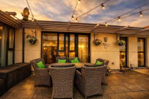 a patio with a table and chairs and a couch at Skyline Luxury Penthouse Belfast City Centre in Belfast