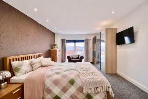 a bedroom with a large bed and a television at Skyline Luxury Penthouse Belfast City Centre in Belfast +59 photos