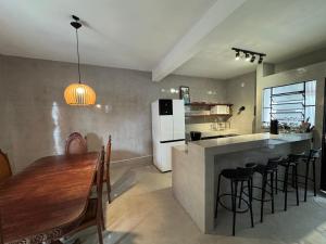 a kitchen with a wooden table and a kitchen with a refrigerator at TuriHouse - Ilha Grande in Abraão +57 photos