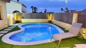 a swimming pool with a chair next to a house at Casa La Gavina in Riumar