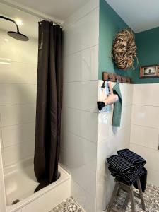a bathroom with a shower and a stool next to a tub at Stadtwohnung Hygge Home in Neustadt in Holstein