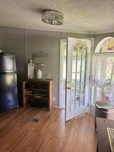 a living room with a refrigerator and a door at 3 bedroom River cabin retreat ! in Terre Haute