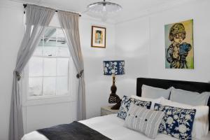 a bedroom with a bed with blue and white pillows at Cedar Cottage Daylesford in Daylesford