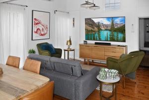 a living room with a couch and a flat screen tv at Cedar Cottage Daylesford in Daylesford