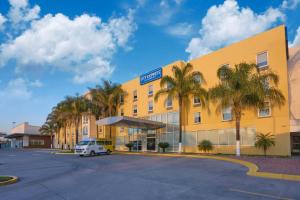 a yellow building with a car parked in front of it at City Express by Marriott Tepotzotlán in Tepotzotlán