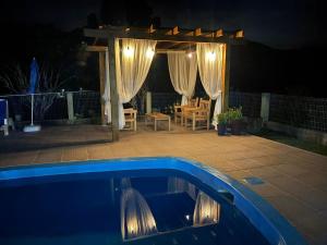 a swimming pool in front of a patio at night at Morada do Campo in Biguaçu