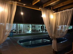 a pool with white curtains in a building at Morada do Campo in Biguaçu +84 photos
