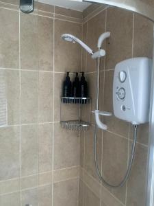 a shower with a shower head in a bathroom at Rose Cottage Moira in Moira +20 photos