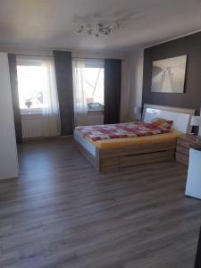 a bedroom with a large bed and two windows at Pension-Auszeit in Giesen