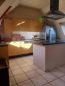a kitchen with wooden cabinets and a tile floor at Pension-Auszeit in Giesen
