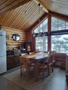 a dining room with a wooden table and chairs at Villa Kalkonniemi in Kemijärvi