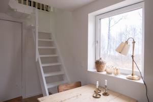 a white room with a ladder and a table and a window at Bokskogen stugby hus två in Jönköping