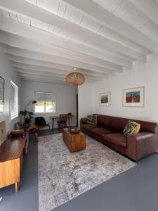 a living room with a couch and a table at 1 Fountain private pool in Hout Bay