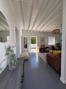 a living room with a couch and a table at 1 Fountain private pool in Hout Bay