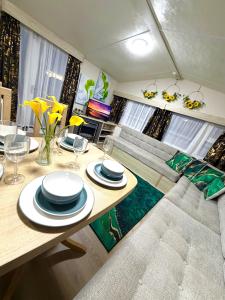 a living room with a table and a couch at Lyons Robin Hood Caravan in Rhyl-5 min walk to Beach ,FREE Wi-Fi and FREE parking for 4 cars, sleeps up to 8 people-3 bedrooms in Rhyl