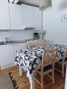 a kitchen with a table with a black and white table cloth at Nivan Majoitus Nivan koulu in Joensuu