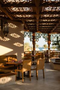 a dining room with tables and chairs and a wall at Grand Palace - Couples only 18 years plus in Hurghada