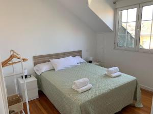 a bedroom with a bed with two towels on it at Apartamento somo SARR in Somo