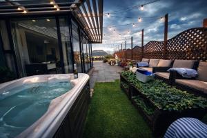 a hot tub on a patio with a couch and a table at Skyline Luxury Penthouse Belfast City Centre in Belfast