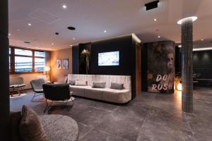 a living room with a couch and a tv at Revier Boutique Hotel Kaprun in Kaprun