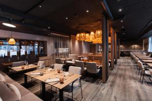 a restaurant with tables and chairs and chandeliers at Revier Boutique Hotel Kaprun in Kaprun