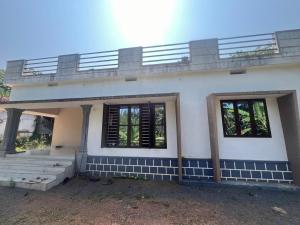 a house with a balcony on top of it at Hillocks and The Spring in Sampaji