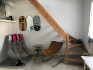 a living room with a chair and a staircase at Gipsy Chic Duplex on the beach in Carolles
