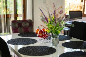a table with a bowl of fruit and a vase of flowers at Villa Komitata-Pool and Jacuzzi in Balchik +46 photos