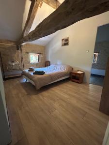 a bedroom with a bed and a wooden floor at Poitevins in Saint-Astier