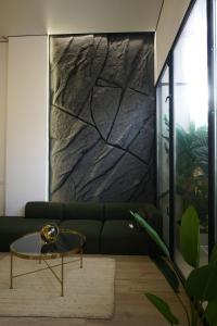 a living room with a green couch and a stone wall at Cliff Appart in Valencia
